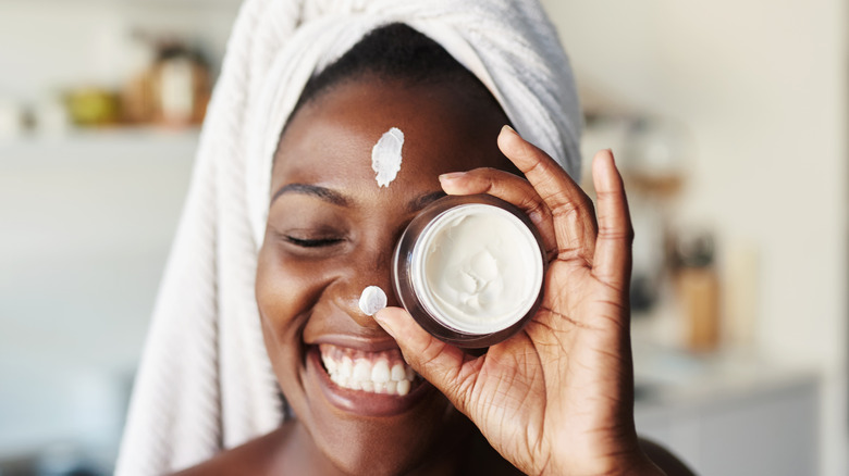 Woman holding moisturizer in hand