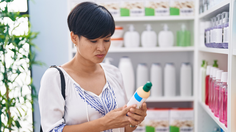 Woman looking at a shampoo bottle