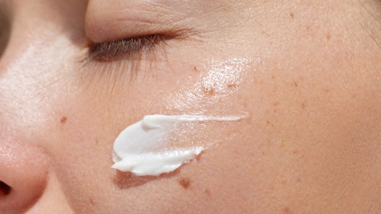 Person applying moisturizer to their face