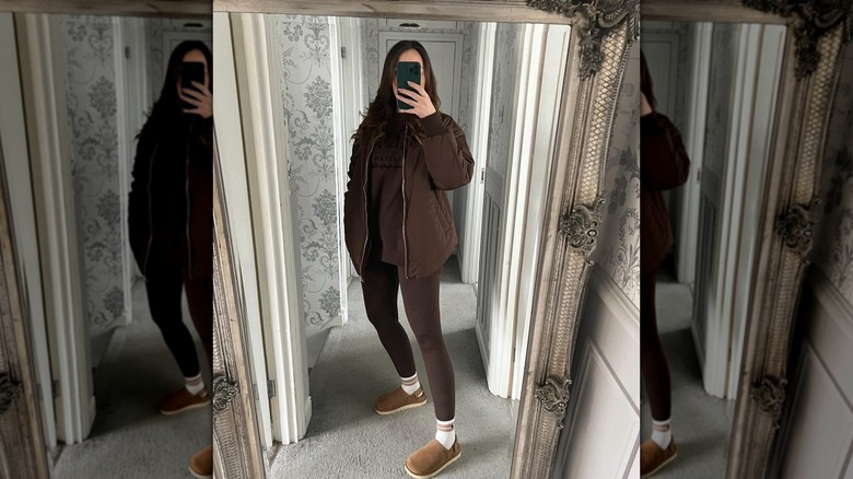 A woman takes a mirror selfie of her monochrome outfit