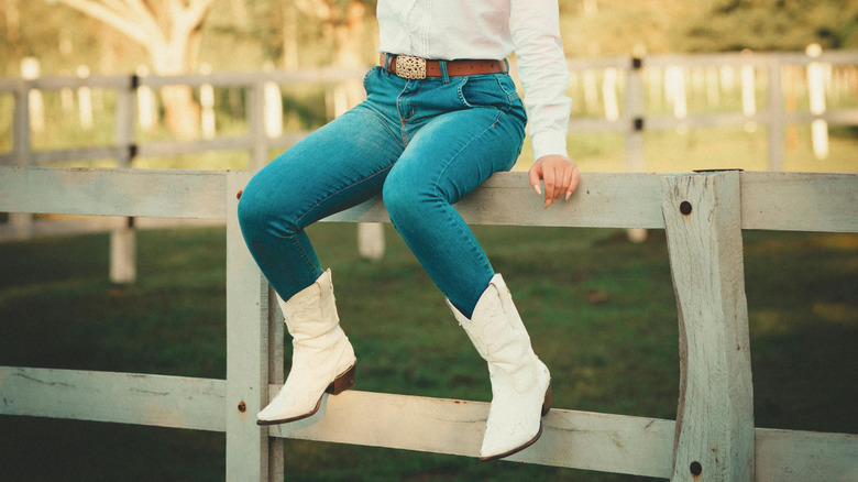 woman in skinny jeans and white cowboy boots