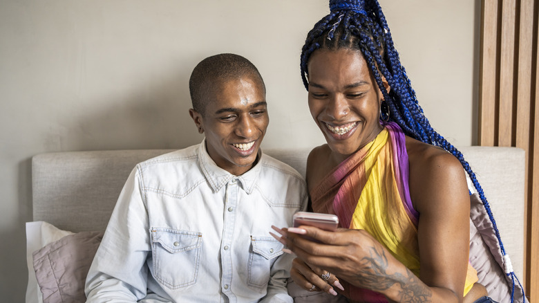 Queer couple look at phone