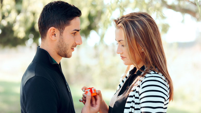 unhappy woman receives gift from partner