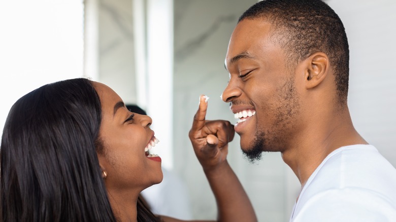 girl smiling pointing smiling man