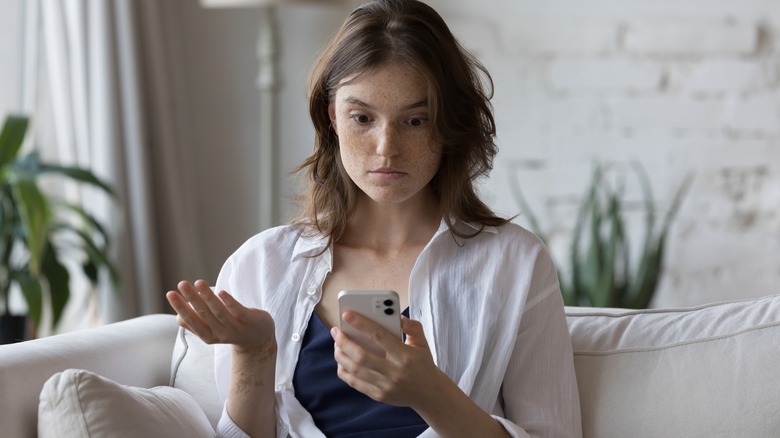 Upset woman looking at phone