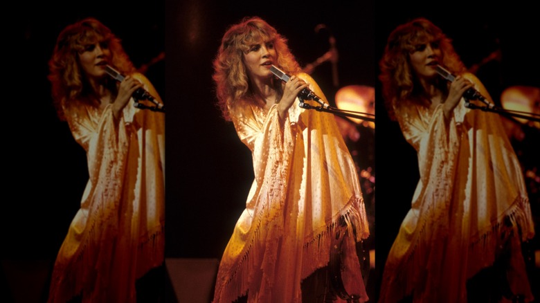 Stevie Nicks performing onstage draped in a silky shawl