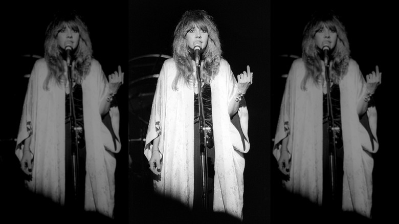 A black-and-white photo of Stevie Nicks onstage singing
