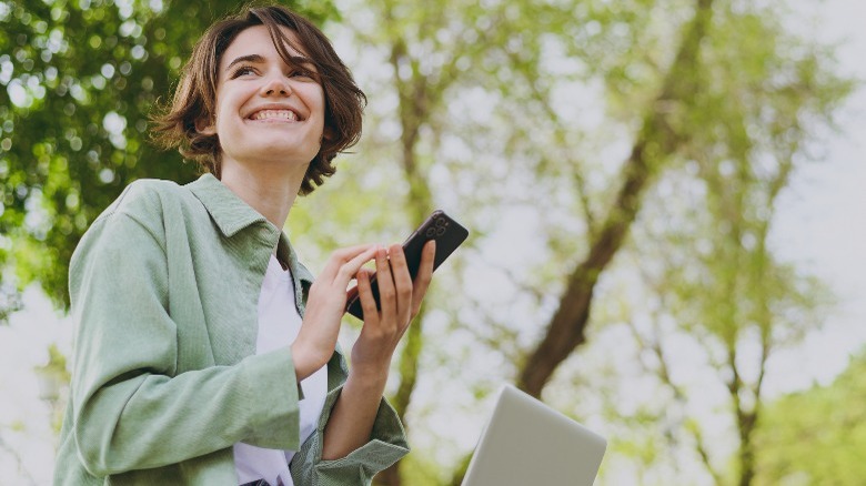 Woman smiling holding a phone