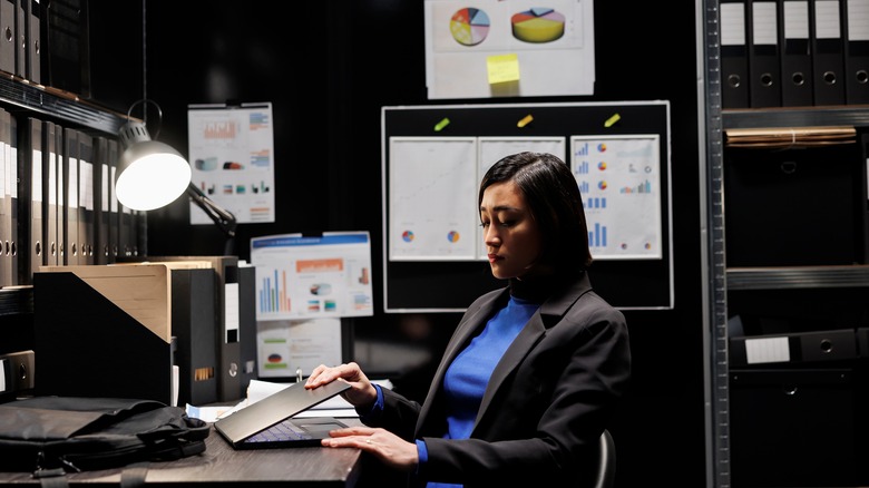 Tired woman closing work laptop
