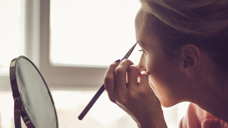 Woman applying eyebrow makeup