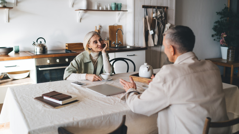 A mature couple having a conversation at a table