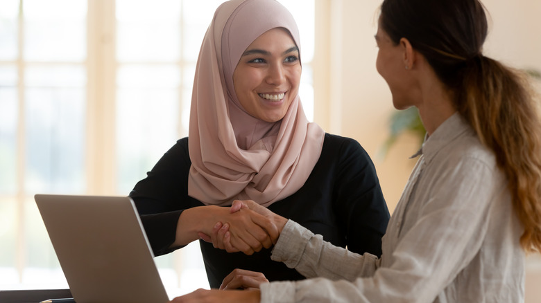 Women shaking hands and smiling