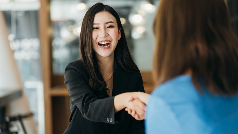 Woman smiling and shaking hand