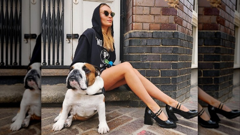 Woman sitting on stoop with bulldog
