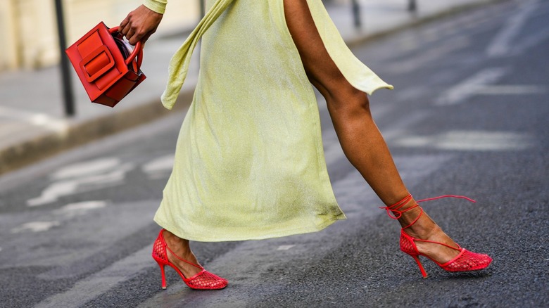 Woman wearing yellow dress, red heels and red bag