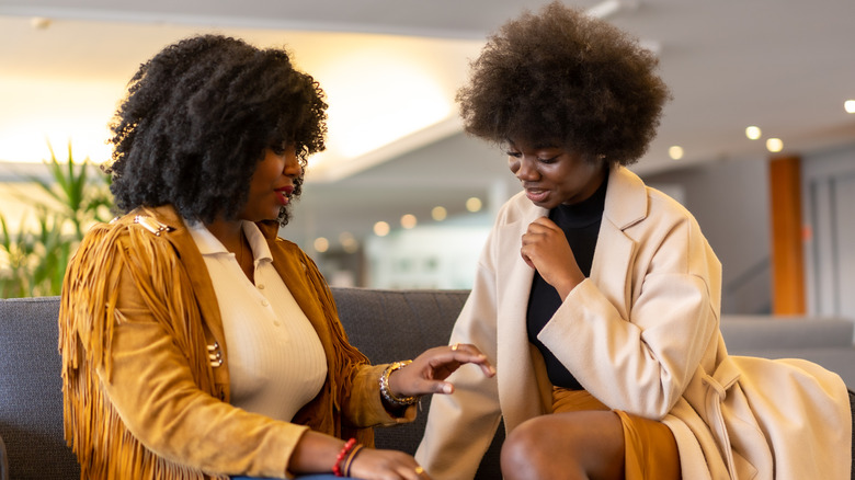 Two women talking on a couch