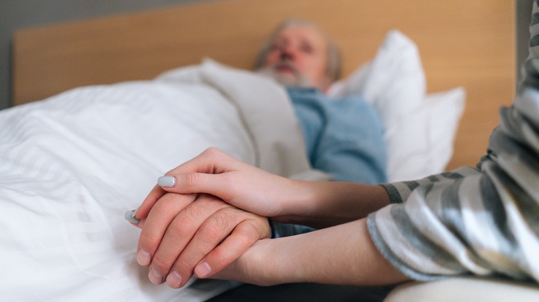 woman holding sick man's hand