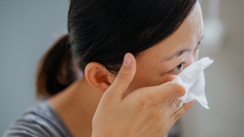 Woman removing eye makeup with wipe