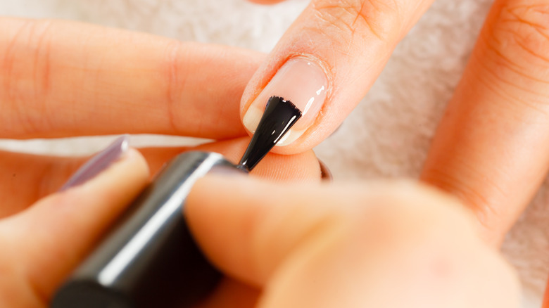 woman using base coat nail polish