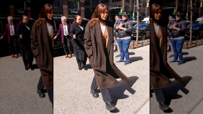 Elizabeth Olsen pictured wearing a long, borwn coat and black chelsea boots