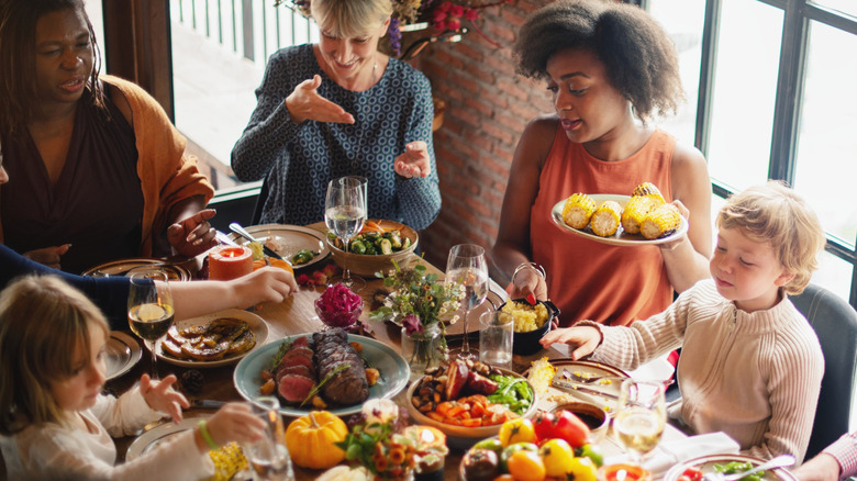 A multigenerational family sitting around a table filled with food