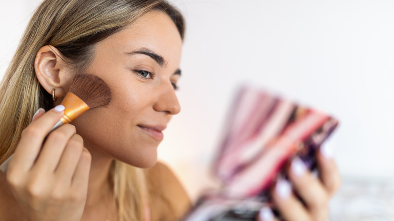 woman applying blush