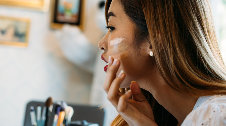 Woman using orange color corrector