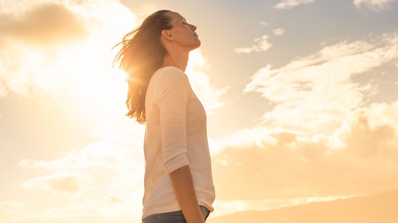 Woman against sunny sky