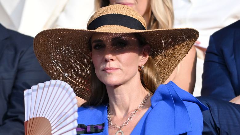Kate Middleton in a straw hat at Wimbledon in a blue dress