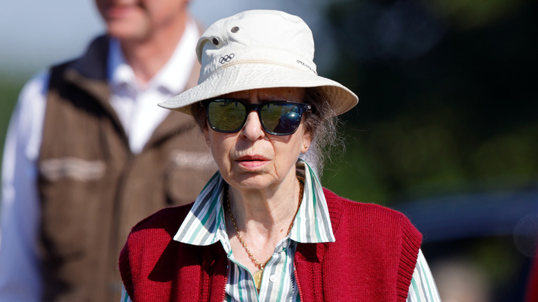 Princess Anne in a bucket hat and a red vest at an event