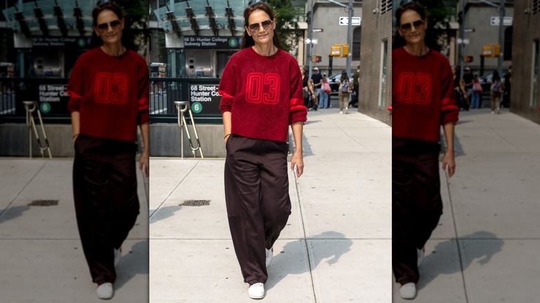 Katie Holmes in brown pants and a red sweater