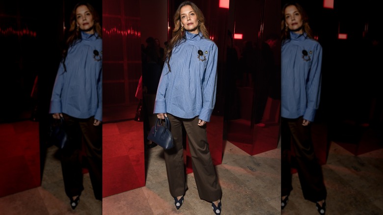 Katie Holmes in a brown pair of pants with a backwards blue shirt