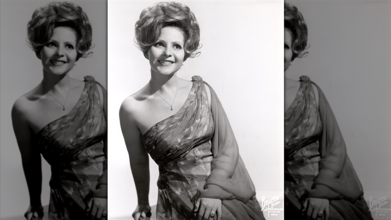 Brenda Lee smiles wearing an off-the-shoulder gown