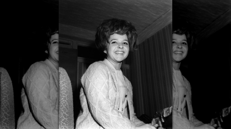 Brenda Lee smiles with a voluminous bouffant and a cardigan
