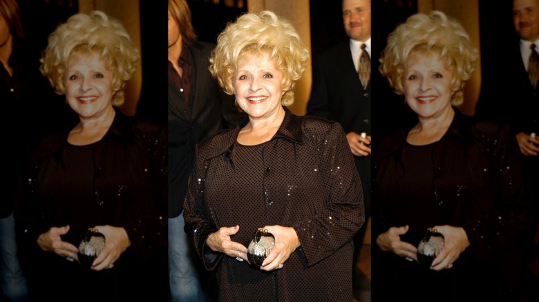 Brenda Lee smiles with a blond bouffant wearing a sparkly black top
