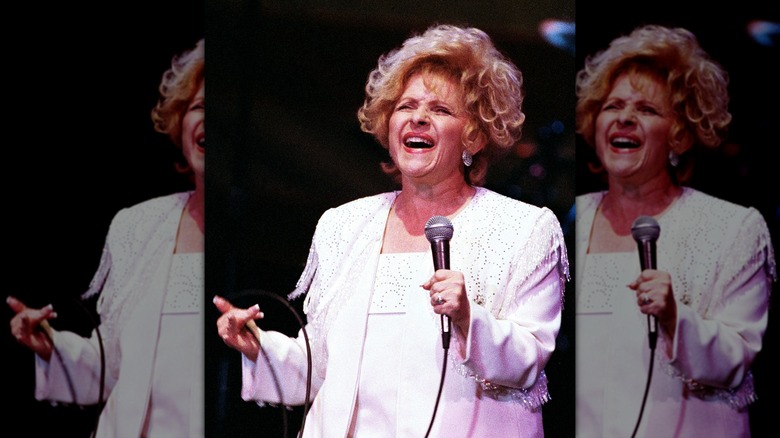 Brenda Lee singing wearing a white Western-style suit