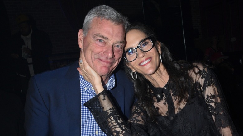 Jami Gertz with her hand on Tony Ressler's face at the Magic City: An American Fantasy premiere afterparty in 2024