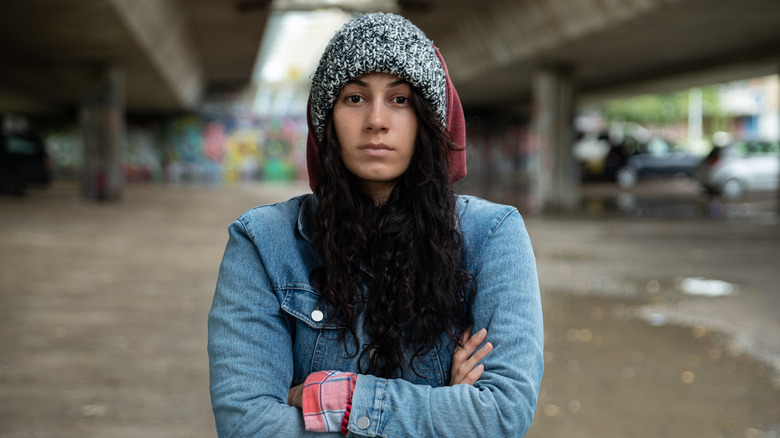 woman standing in alleyway with arms crossed