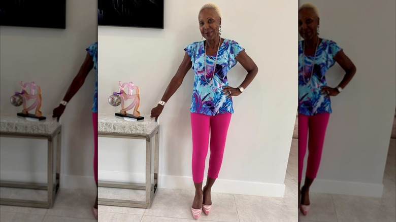 A woman wearing pink capri pants and a patterned blue top