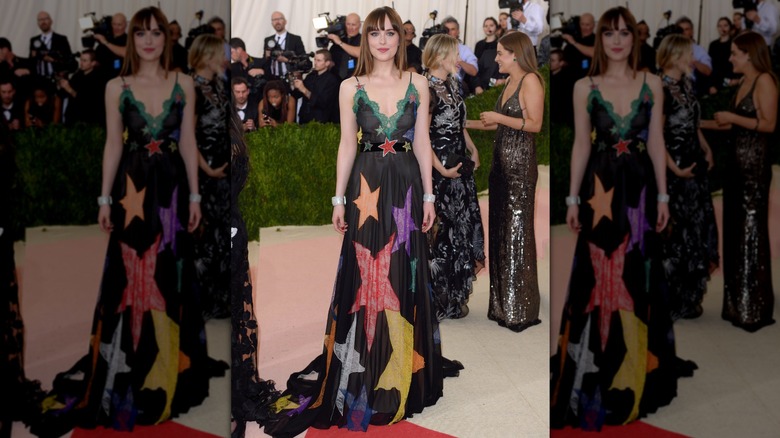 Dakota Johnson wearing a lace-trimmed gown decorated with stars at the 2016 Met Gala