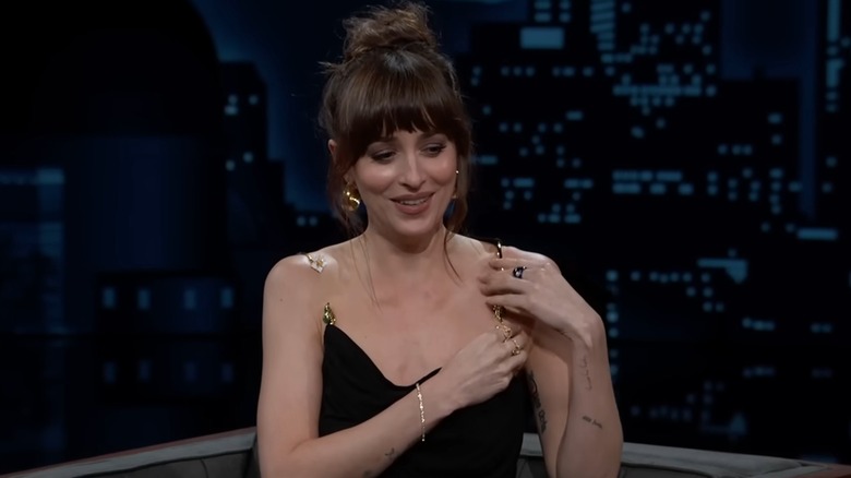 Still of Dakota Johnson fiddling with her broken dress strap on "Jimmy Kimmel Live"