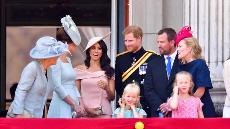 Camilla, Kate Middleton, Meghan Markle, Prince Harry, and other members of the royal family chatting amongst themselves