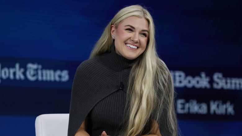 Erika Kirk at an event wearing a long grey cape dress with her hair down