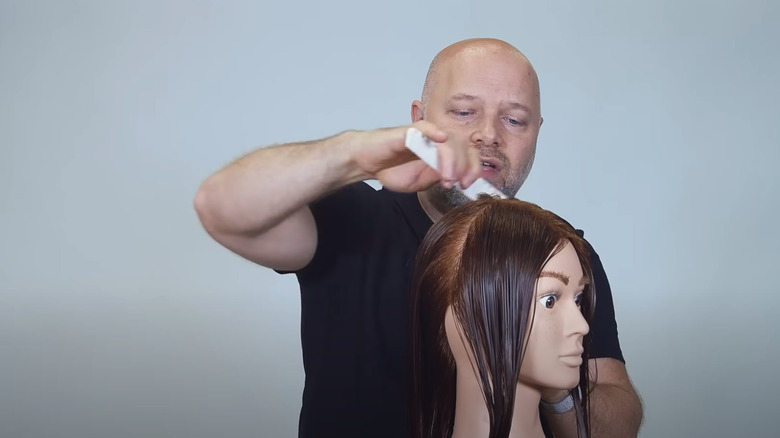 Man cutting hair on a mannequin head