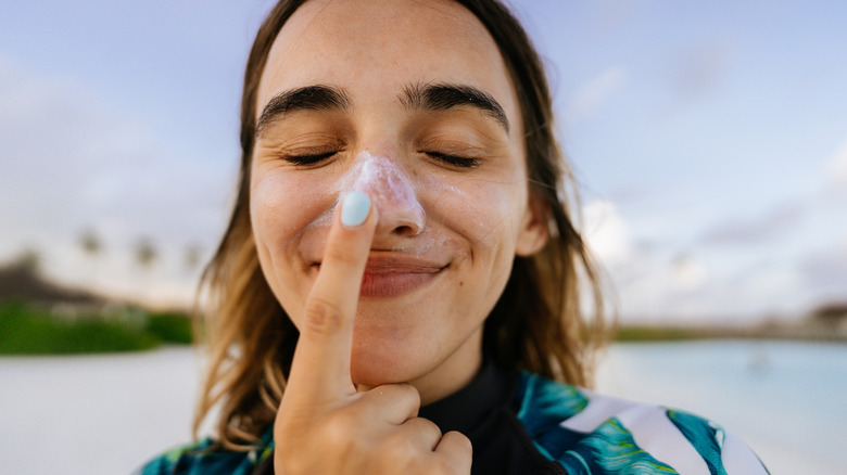 Woman applying sunscreen to face