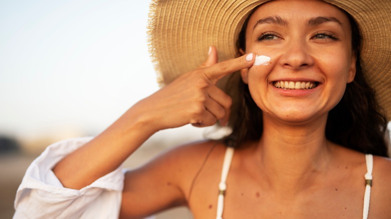 A woman applying SPF on her face