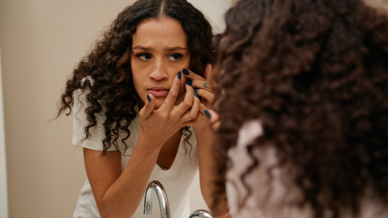 woman popping a zit