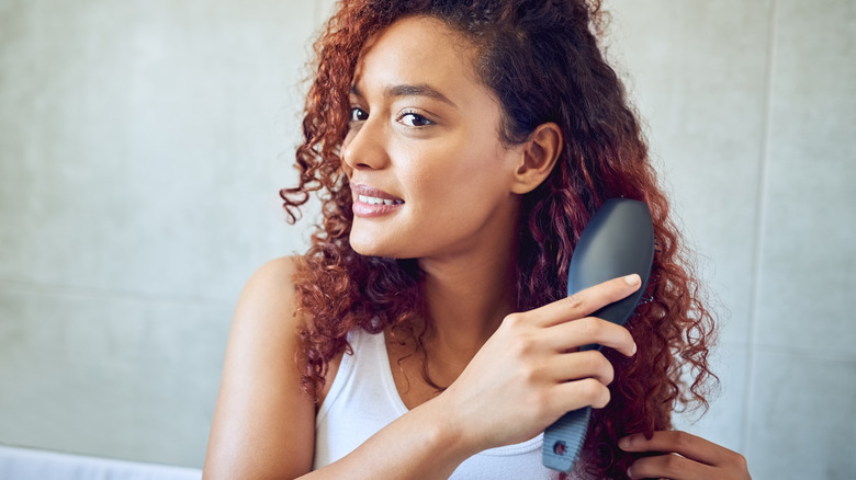 Curly-haired woman brushing her hair