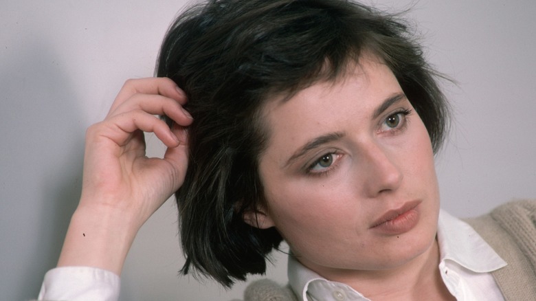 Isabella Rossellini with a neutral expression and her hand on her head in 1986