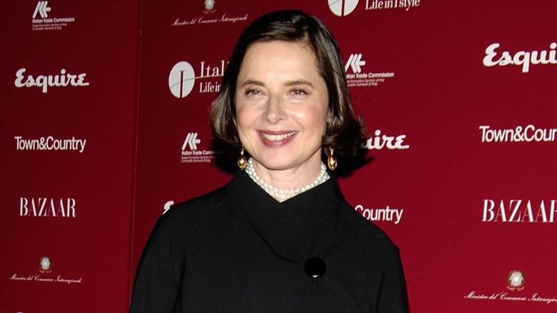 Isabella Rossellini smiling in front of a red background in 2008